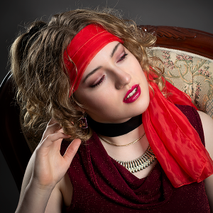 Wrapped in thought. Leah Bell in a contemplative portrait seated in a vintage chair with a headscarf.