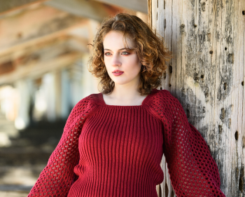 Tide line. Leah Bell in a coastal portrait beneath Coffs Harbour Jetty, resting against the structure.
