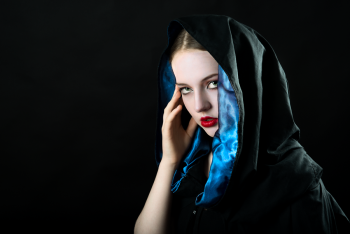 Veiled drama. Leah Bell in a moody portrait with dark, sculptural styling for a theatre promotion.