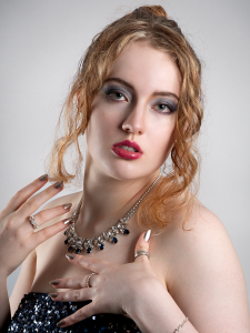 Gilded light. A dramatic portrait of Leah Bell, where movement in fabric and the curve of the staircase create a sense of elegance, scale, and theatrical presence.