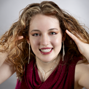 Ease and light. Leah Bell smiling in a studio portrait.